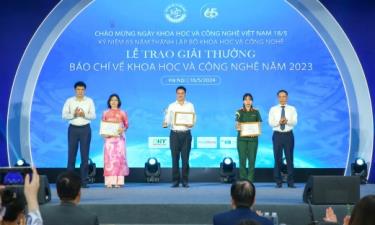 Nhà báo Nguyễn Đức Lợi và đại diện ban tổ chức trao giải cho nhóm tác giả, tác giả đạt giải Ba.