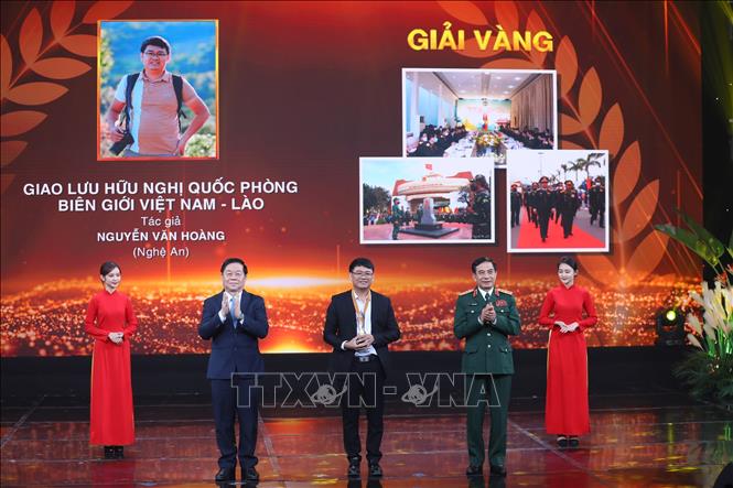 Đại tướng Phan Văn Giang và Trưởng Ban Tuyên giáo Trung ương Nguyễn Trọng Nghĩa trao Cup và Huy chương Vàng cho tác giả Nguyễn Văn Hoàng (Nghệ An) tác phẩm “Giao lưu hữu nghị Quốc phòng Việt Nam - Lào”. Ảnh: Hoàng Hiếu/TTXVN