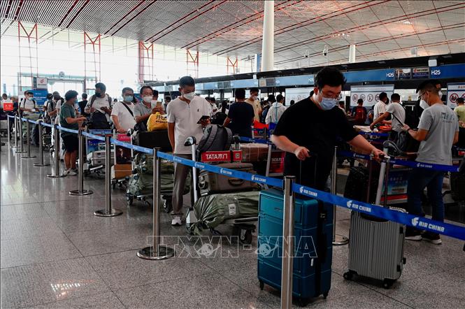 Hành khách làm thủ tục tại sân bay quốc tế ở Bắc Kinh, Trung Quốc. Ảnh: AFP/TTXVN
