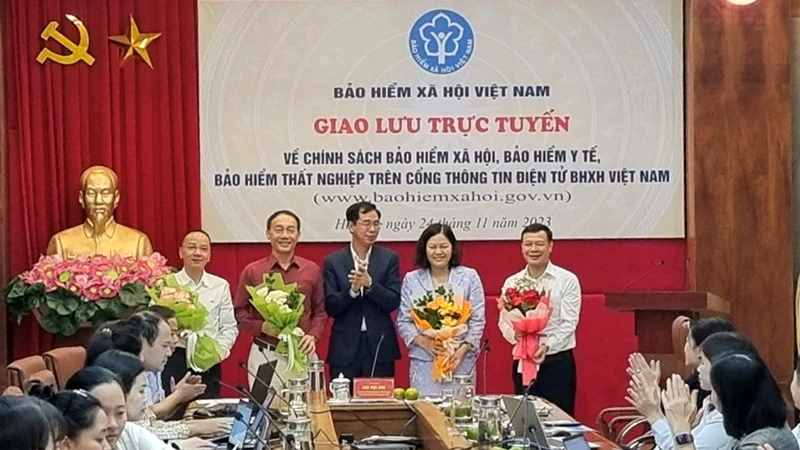 Phó Tổng Giám đốc Bảo hiểm xã hội Việt Nam Đào Việt Ánh tặng hoa khách mời, chuyên gia tham dự giao lưu trực tuyến vào tháng 11/2023. (Ảnh: TÂM TRUNG)