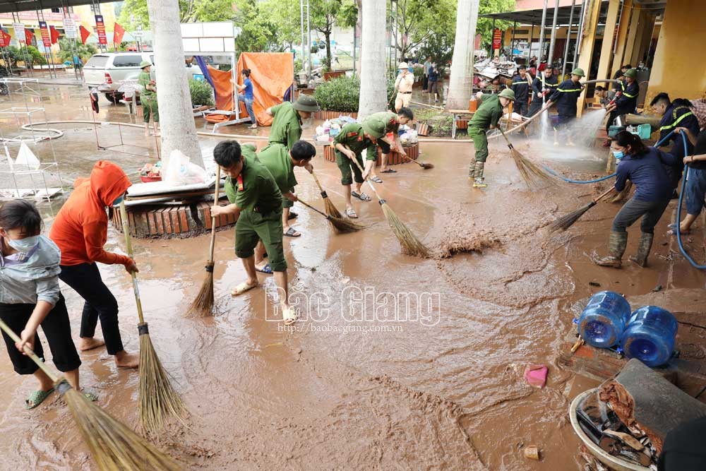 Cán bộ, chiến sĩ Công an huyện Lục Ngạn và người dân địa phương giúp thầy, cô Trường Tiểu học Phong Vân vệ sinh trường, lớp học sau lũ.