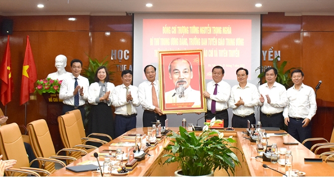 Đồng chí Nguyễn Trọng Nghĩa, Bí thư Trung ương Đảng - Trưởng ban Tuyên giáo Trung ương tặng quà lưu niệm của Ban Tuyên giáo Trung ương cho Học viện Báo chí và Tuyên truyền. Ảnh: Mai Nghiêm