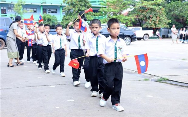 Giáo viên Trường Song ngữ Lào-Việt Nam Nguyễn Du đón học sinh lớp 1 vào Trường trong Lễ Khai giảng. (Ảnh: Phạm Kiên/TTXVN)