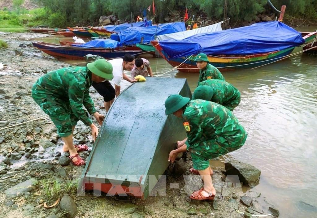 Cán bộ, chiến sĩ Đồn Biên phòng cửa khẩu cảng Cửa Lò - Bến Thuỷ (Bộ đội Biên phòng tỉnh Nghệ An) tăng cường lực lượng xuống địa bàn phối hợp với chính quyền địa phương, các lực lượng hỗ trợ ngư dân đưa thuyền cá lên bờ tránh trú bão. Ảnh: TTXVN phát
