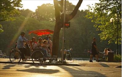 Du khách trải nghiệm du lịch quanh hồ Hoàn Kiếm bằng xích lô. Ảnh: Khánh Hòa/TTXVN