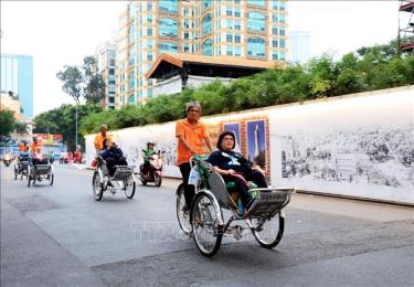 Khách quốc tế tham quan trung tâm TP Hồ Chí Minh bằng xích lô. Ảnh: Hồng Đạt/TTXVN