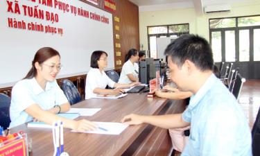 Cán bộ Trung tâm phục vụ hành chính công xã Tuấn Đạo hướng dẫn người dân nộp hồ sơ thủ tục hành chính.