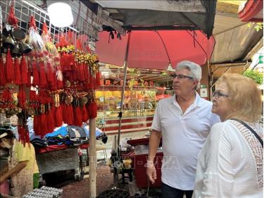 Khách du lịch nước ngoài trước hàng bán đồ trang trí Tết tại khu Chinatown ở Bangkok.