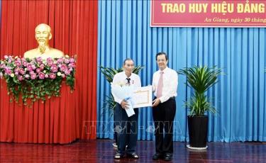 Ông Lê Hồng Quang, Bí thư Tỉnh ủy An Giang trao Huy hiệu 65 năm tuổi Đảng cho đảng viên. Ảnh: Thanh Sang/TTXVN