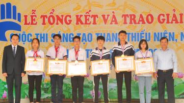 Các đồng chí Phan Thế Tuấn và Nguyễn Xuân Tiến trao giải Nhất cho nhóm tác giả thuộc hai khối THCS và THPT.
