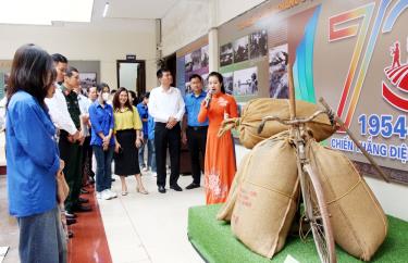 Đại biểu và các em học sinh tham quan khu vực trưng bày chiếc xe đạp thồ - phương tiện vận chuyển lương thực trong Chiến dịch Điện Biên Phủ.