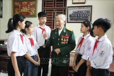 Học sinh trường THCS Thượng Lan, huyện Việt Yên đến thăm hỏi và nghe Anh hùng Chu Văn Mùi kể chuyện. Ảnh: Danh Lam/TTXVN